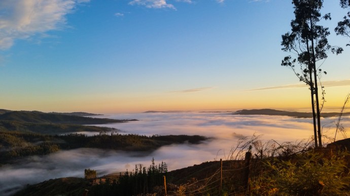 While the sun was rising, the clouds hung low in the valleys. 